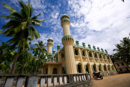 Antique islamic mosque in the green palms on the beach