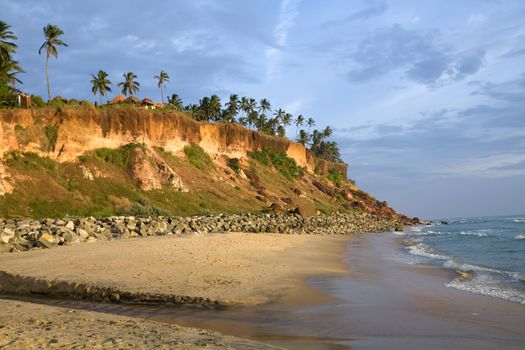 Cliffs on the beach near the ocean over blue sky