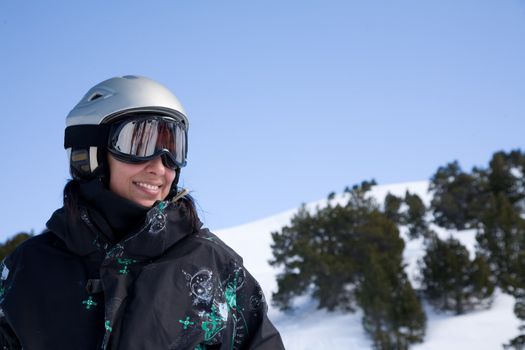 Pretty gorl in snowboard clothes in helmet over blue sky