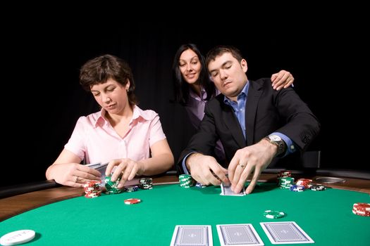 Group of young caucasian adults playing poker on green casino felt