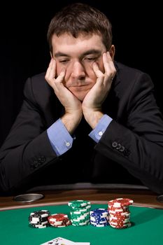 Stylish man in doubt before making bet in the casino