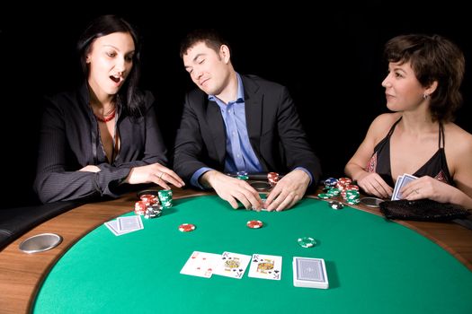 Friends playing poker in the casino at night