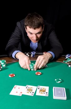 Stylish man in black suit making bet in the casino