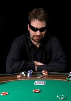 Man in black shirt plaing poker in the casino 