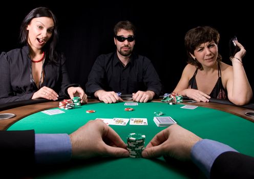 Company of friends having fun in the casino poker table