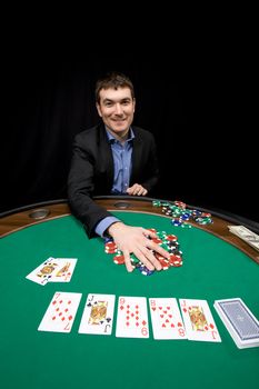Smiling caucasian man win chips in casino poker