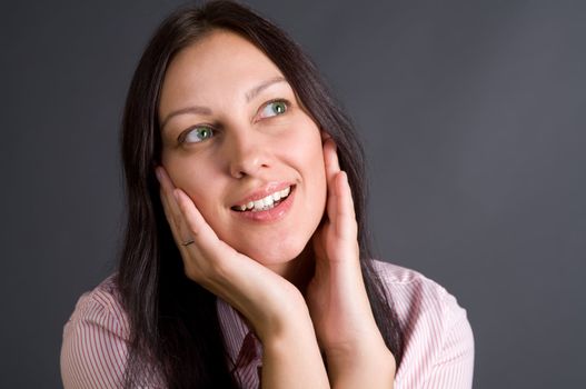 Smiling woman closeup portrait over gray in studio