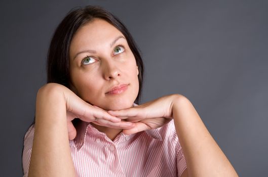 Thoughtful pretty woman close-up portrait over gray concept