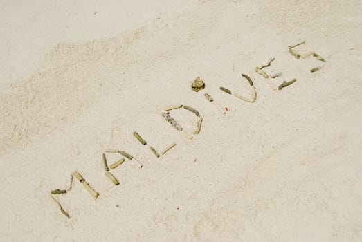 Maldives note written on a white sandy beach