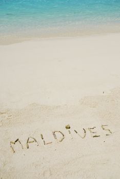 Maldives note written on a white sandy beach