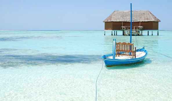 beautiful seascape with honeymoon villa in Maldivian Island and typical boat