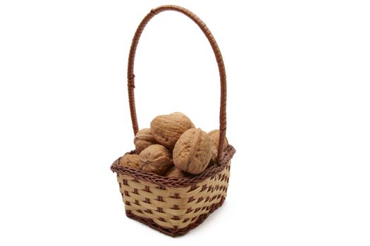 Walnuts in wicker basket isolated on white background