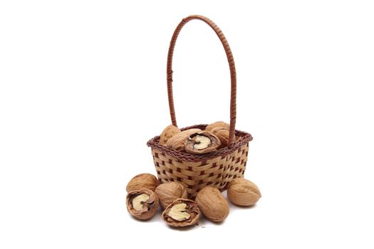 Walnuts in wicker basket isolated on white background