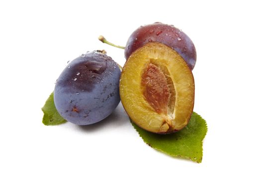 Whole plum and halves isolated on the white background