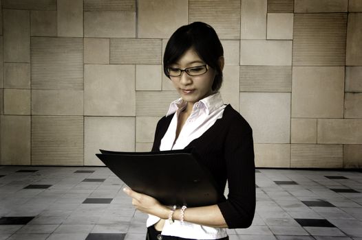 Young women holding a file, business/educational purpose.
