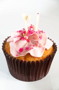 Beautiful cupcake decorated with frosting and dragees