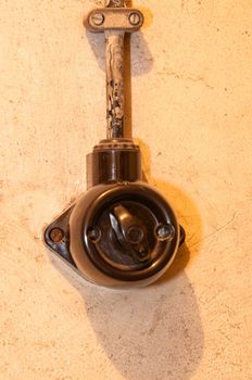 Old black lightswitch (bakelite) mounted on rough wall