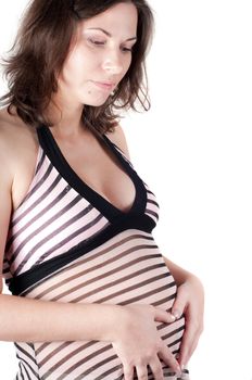 Pregnant woman holding her hands in form of heart sign on her belly