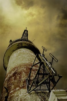 old lighthouse against stormy sky 
