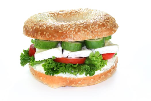 Bagel topped with a camembert cheese, cucumber and tomato

