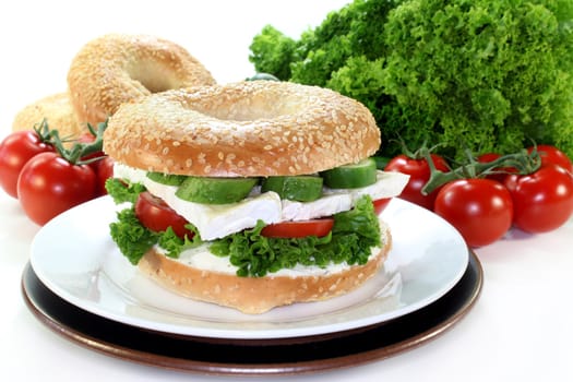 Bagel topped with a camembert cheese, cucumber and tomato