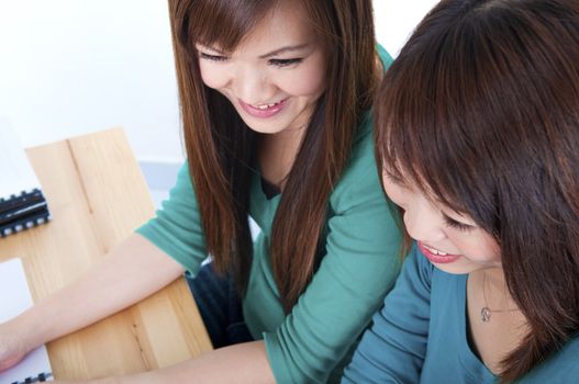 Two Asian female students studying in classroom