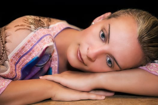 Portrait of a beautiful young caucasian woman resting on her arms and thinking