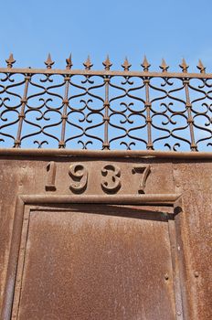 Rusty iron gate, dated 1937, in Portugal