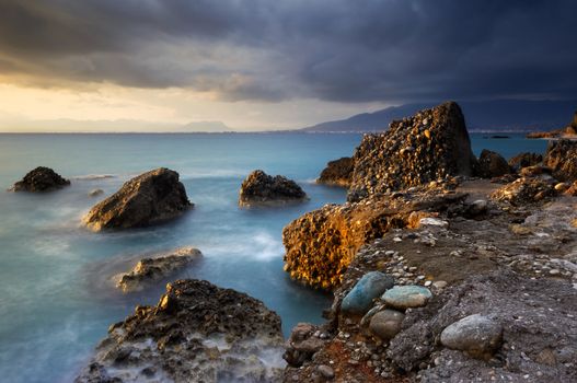 Image shows a rocky seascape during a windy late afternoon