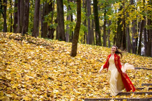 lady in medieval red dress in the autumn forest
