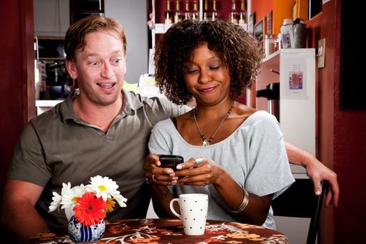 Mixed race Couple in Restaurant with Handheld Phone