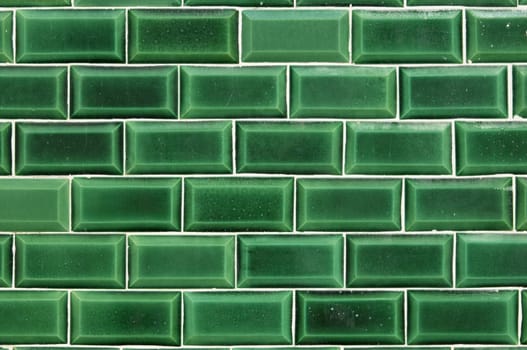 Closeup of a wall covered with green decorative tiles