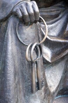 Element of a bronze sculpture. The hand holds two keys.