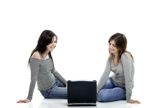 Two female young students working with a laptop