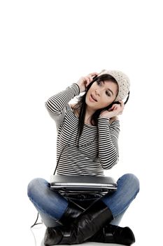Young woman working with a laptop and listen music at the same time
