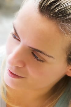 Portrait image of a beautiful young woman looking pleased, in the morning light