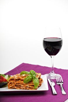 lasagna al forno on a plate with red wine