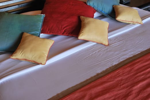 colorful pillows and decoration on a modern hotel bedroom
