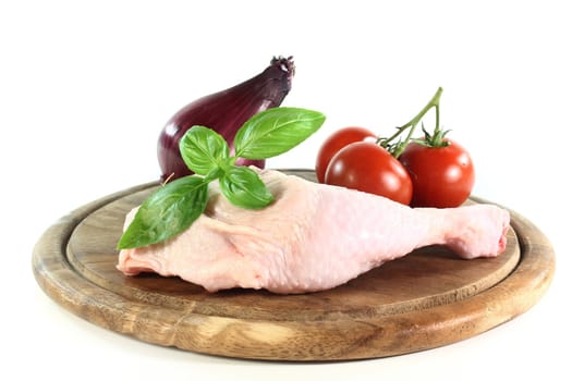 a raw chicken leg in front of white background