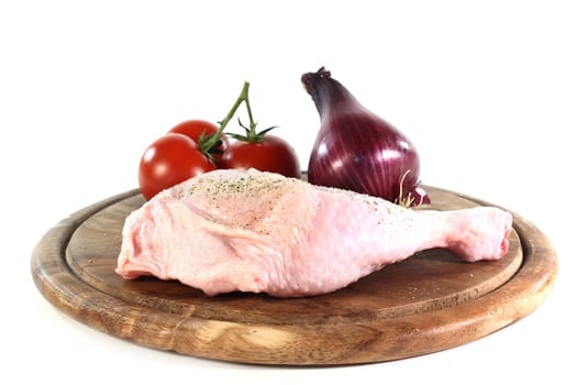 a raw chicken leg in front of white background