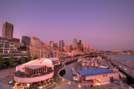 Wide angle view of the city of seattle with its tall buildings, restaurants, streets, and boats in waterfront docks