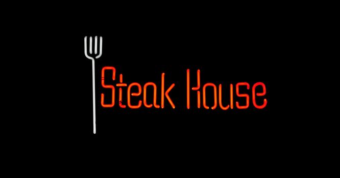 White and red steak house neon on black background
