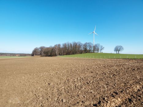 Wind turbine on a clear blue sky  close to a forest