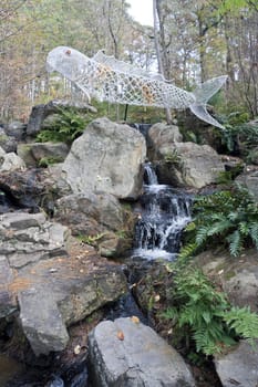A waterfall with a fish statue above