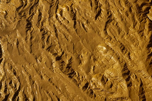 Close-up abstract of wet mud on a tidal river shore. Suitable as an abstract, patterned background.