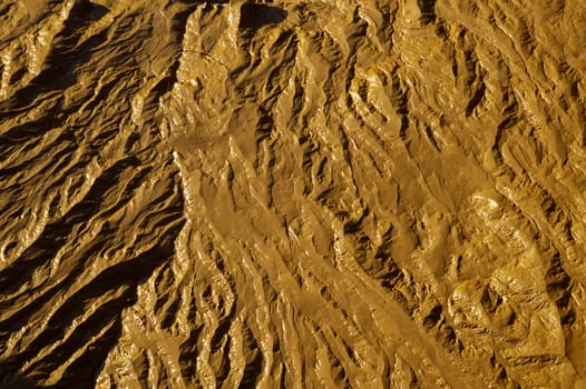 Close-up abstract of wet mud on a tidal river shore. Suitable as an abstract, patterned background.