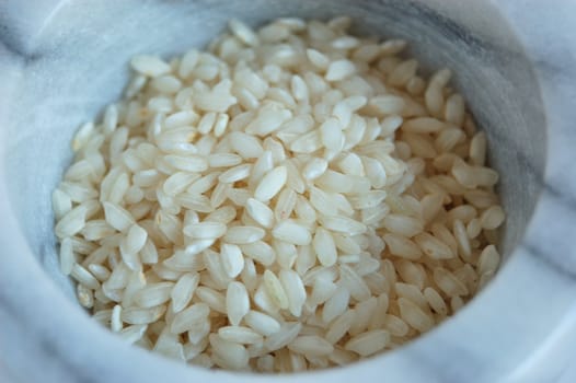 closeup of white rice inside a marble mortar 