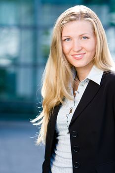 Beautiful blonde girl as business woman in front of office building