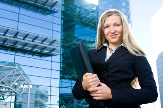 Beautiful blonde girl as business woman in front of office building