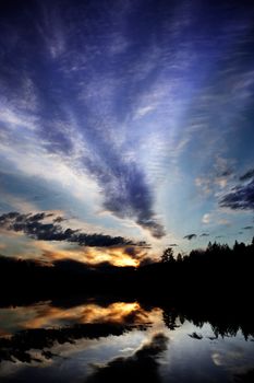 A dramatic sunset over a lake in a forest - Norway